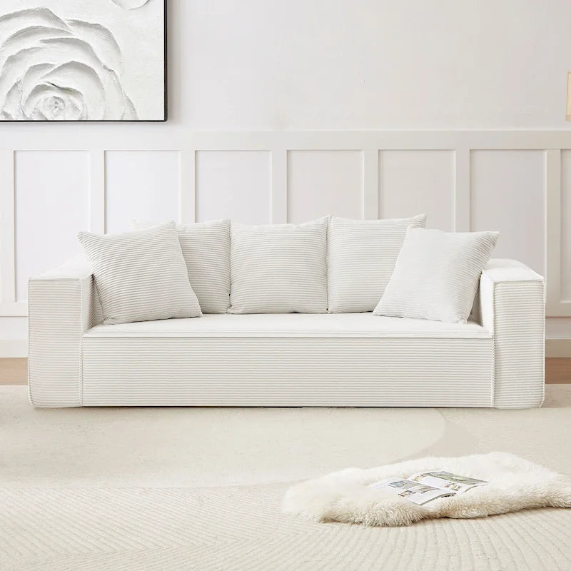 Ce canapé modulaire trois places en velours côtelé est livré avec 5 coussins et présente un design spacieux.