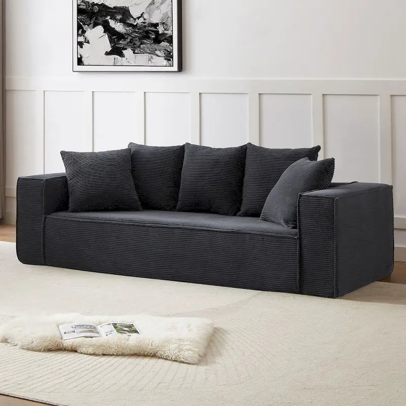 Ce canapé modulaire trois places en velours côtelé est livré avec 5 coussins et présente un design spacieux.