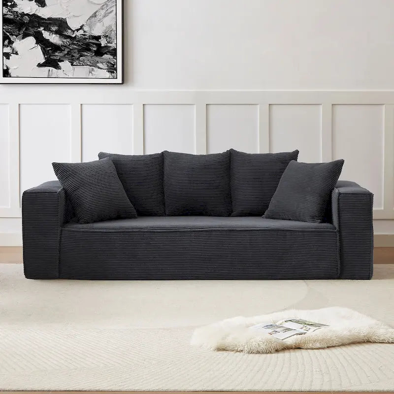 Ce canapé modulaire trois places en velours côtelé est livré avec 5 coussins et présente un design spacieux.