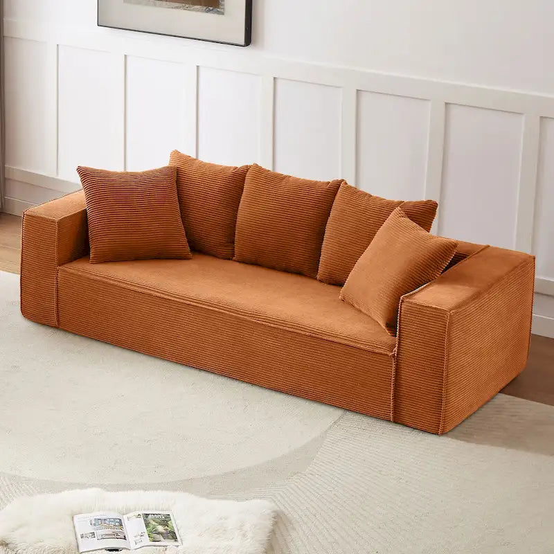 Ce canapé modulaire trois places en velours côtelé est livré avec 5 coussins et présente un design spacieux.