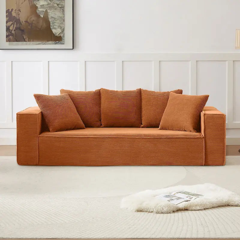Ce canapé modulaire trois places en velours côtelé est livré avec 5 coussins et présente un design spacieux.